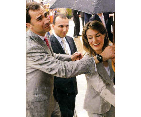 Prince Felipe of Spain holding an umbrella over Princess Letizia